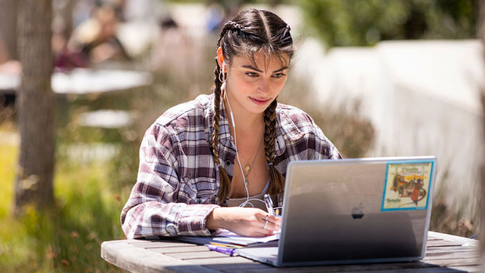 student typing on laptop