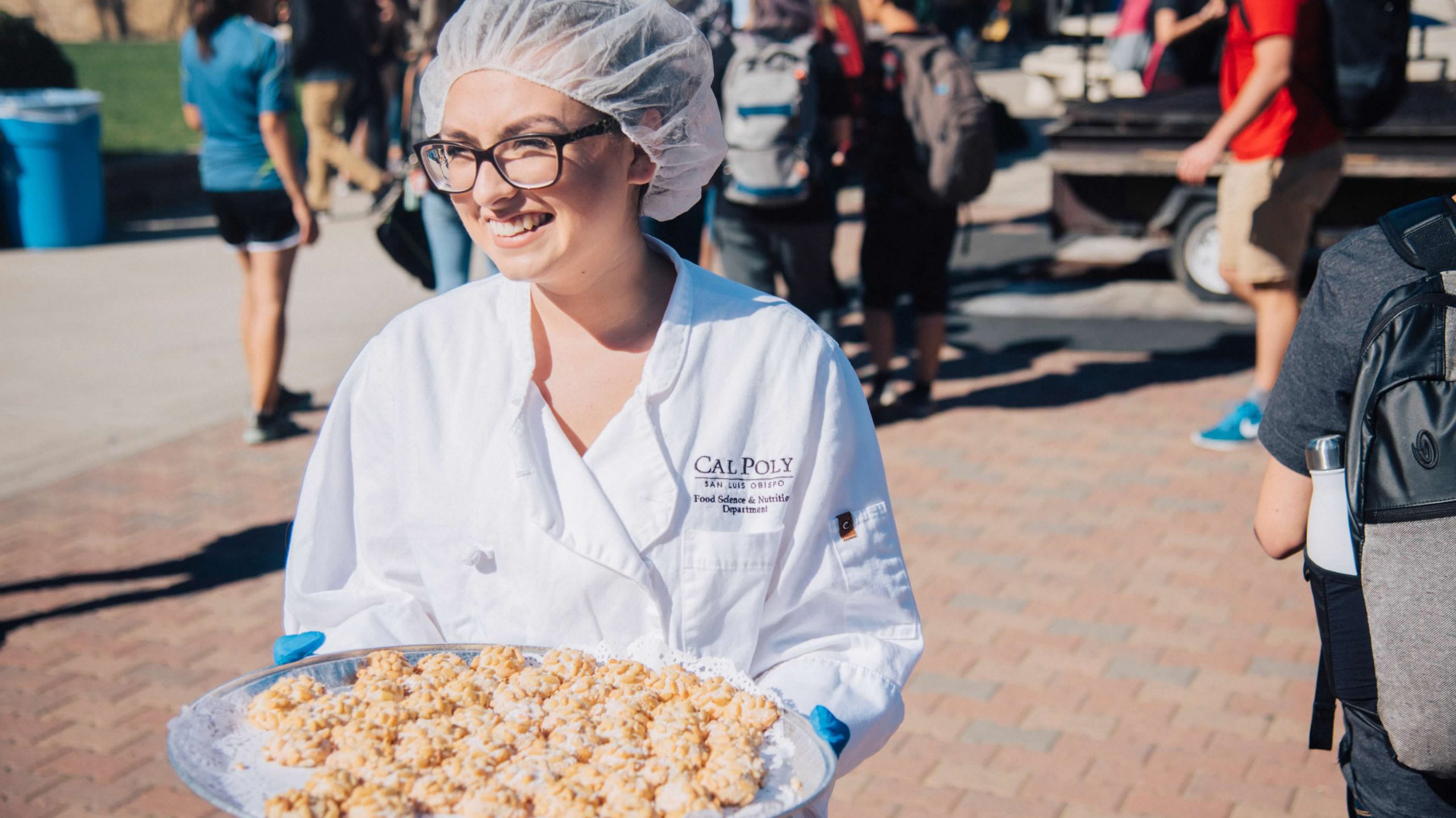 food service student holding tray of hors d'ouvres at taste of the world event