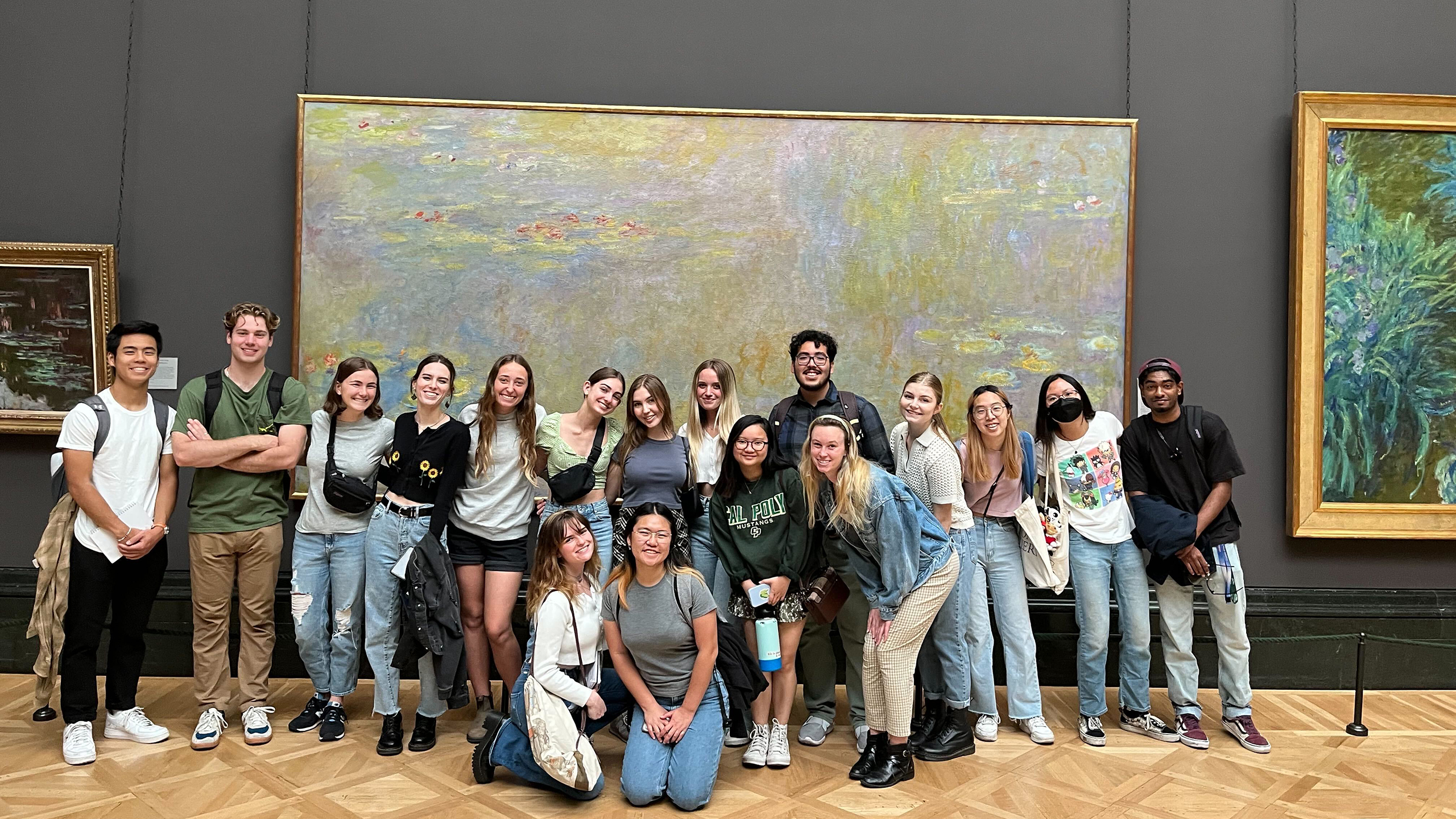Cal Poly Global Scholars pose in front of paintings in an art gallery in London