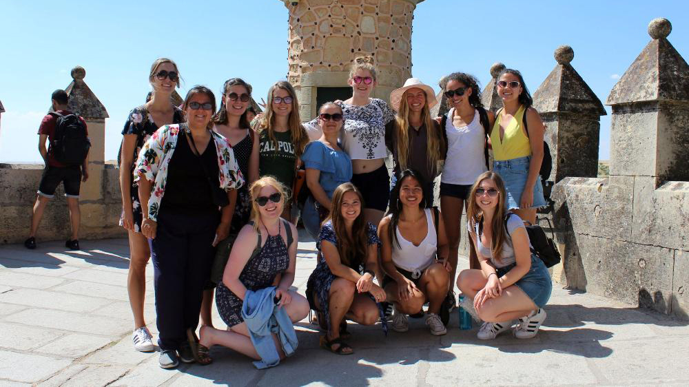 study abroad students pose atop spanish architecture