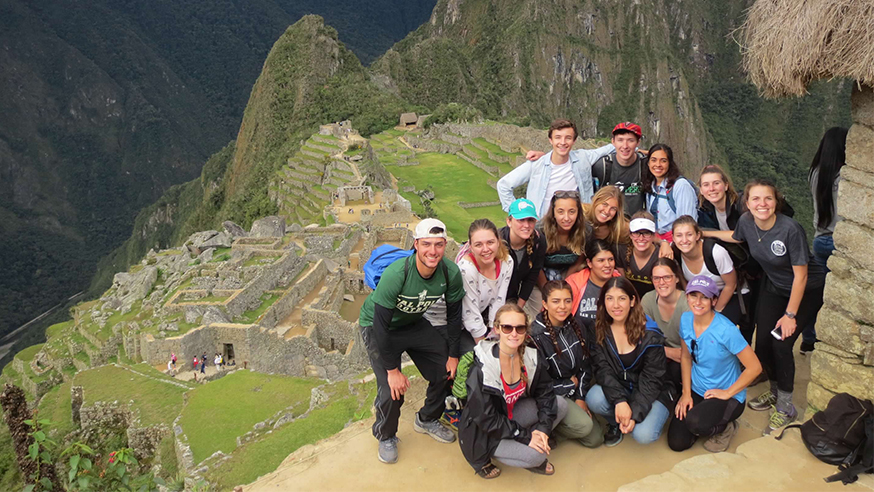 Students smiling as a group with a beautiful mountain view in the background