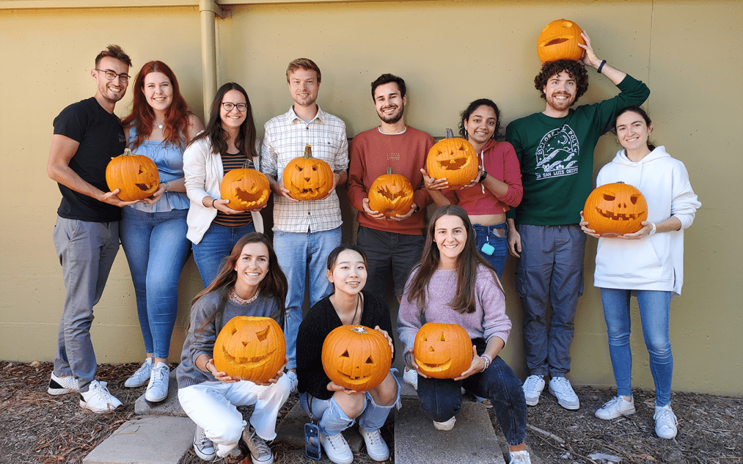 People holding carved pumpkins