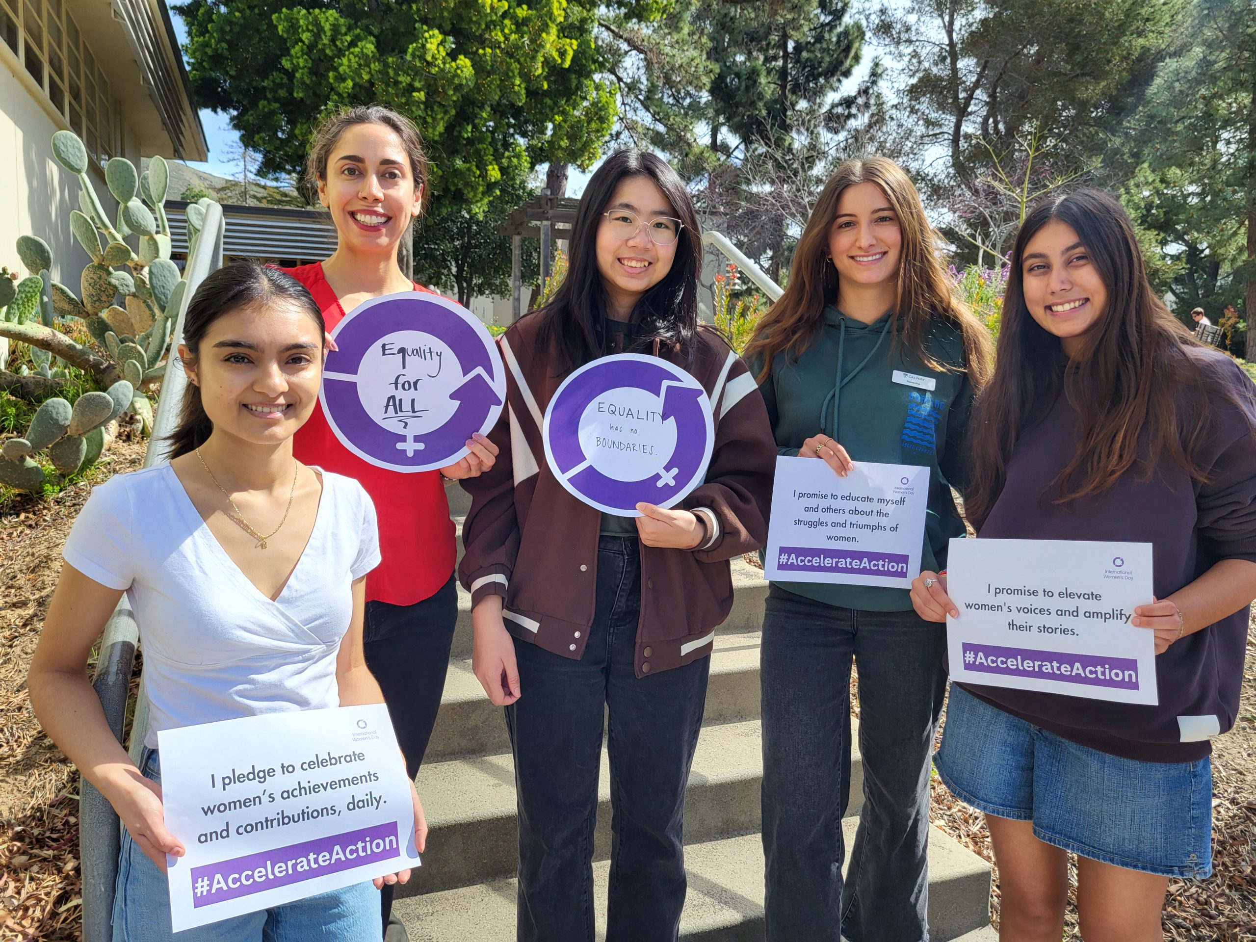 International Women's Day, picture of students and staff holding up signage for the International Women's Day theme #AccelerateAction