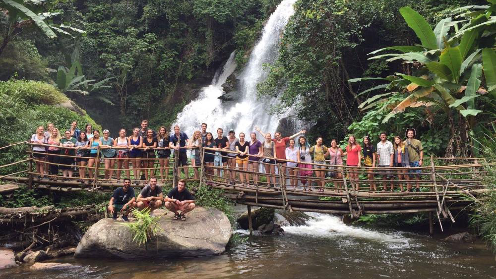 Students standing near a waterfall