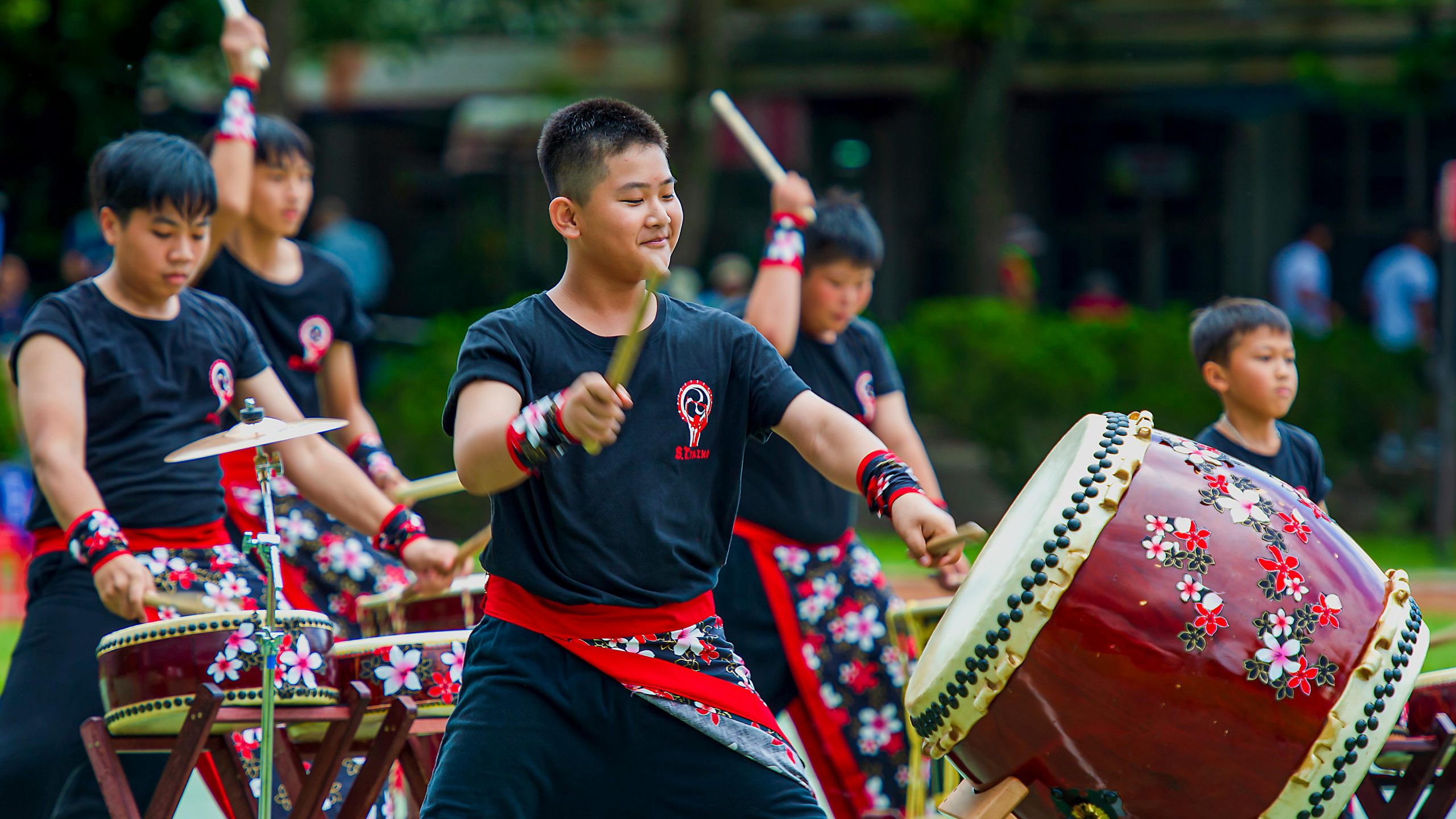 Children performing traditional Japanese taiko drumming at an outdoor cultural festival
